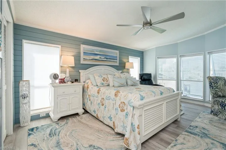Bedroom featuring ceiling fan, a textured ceiling, a closet, light wood-type flooring, and vaulted ceiling