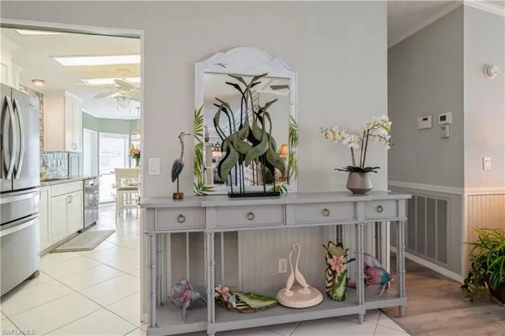 Interior details with stainless steel appliances, a skylight, tile patterned floors, ornamental molding, and ceiling fan
