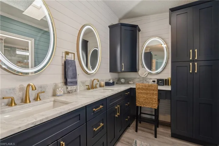 Bathroom featuring vanity, ornamental molding, tasteful backsplash, wood-type flooring, and a textured ceiling