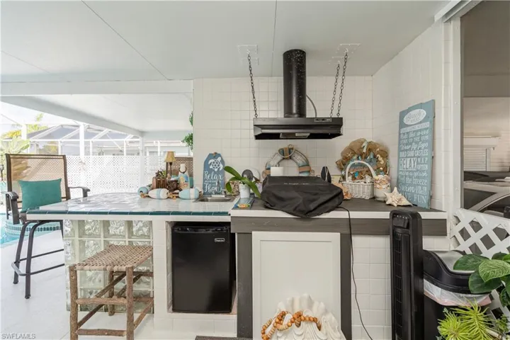 Kitchen with tile walls, decorative backsplash, and extractor fan
