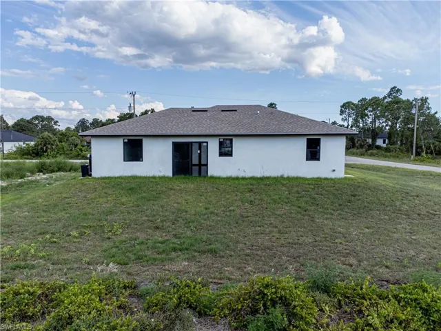 Back of property featuring a yard