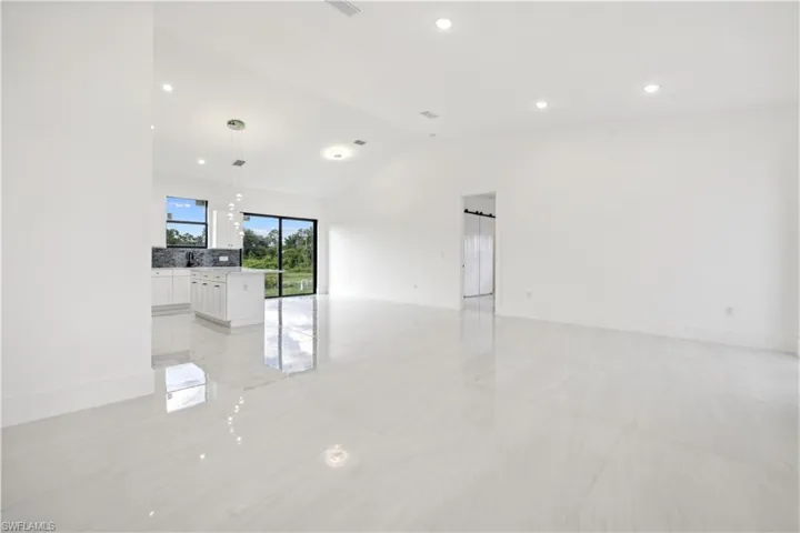 Tiled spare room featuring vaulted ceiling