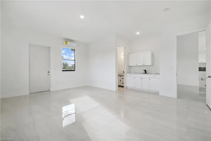 Unfurnished living room with sink and light tile floors