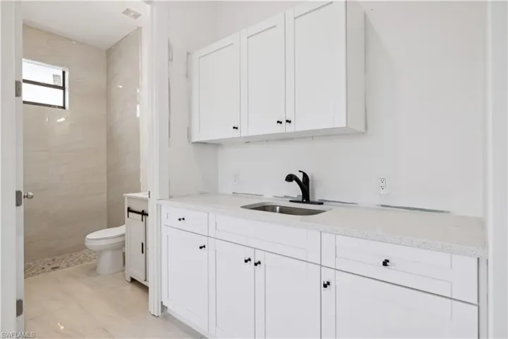 Bathroom featuring tile floors, sink, and toilet