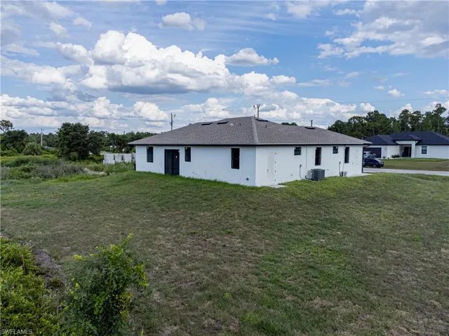 View of home's exterior featuring a yard and central AC