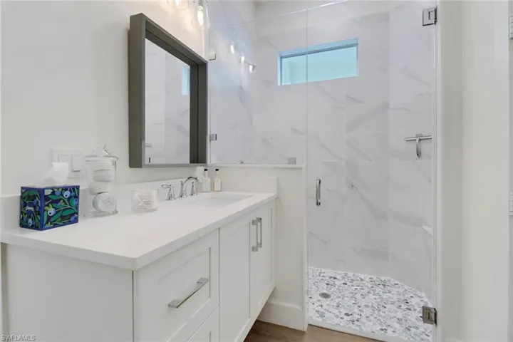 Bathroom featuring a shower with door, vanity, and hardwood / wood-style floors
