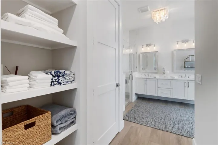 Bathroom with vanity, wood-type flooring, and a shower with shower door