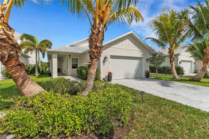 Single story home with a garage and a front lawn