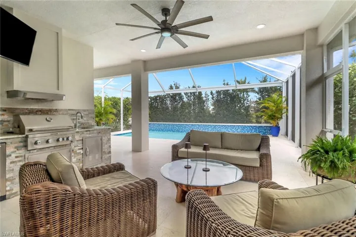 View of patio / terrace with a grill, area for grilling, sink, glass enclosure, and an outdoor living space