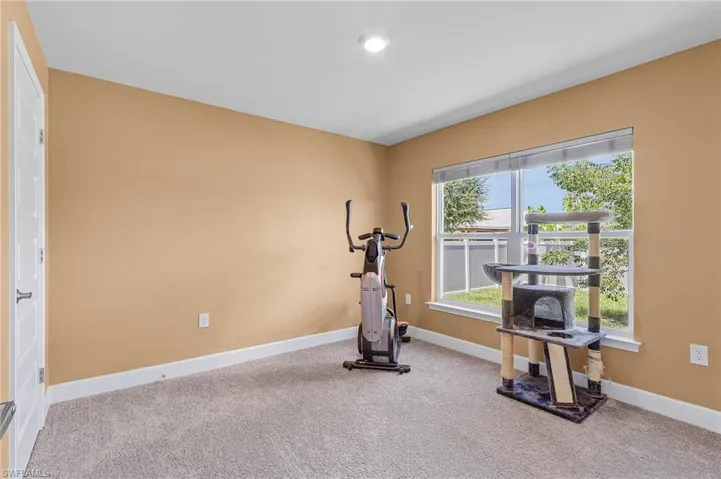 Guest bedroom being used as workout room with carpet flooring