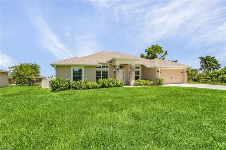 View of front of property with a garage and a front lawn
