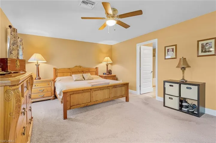 Carpeted bedroom featuring ceiling fan