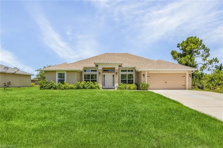 View of front of property with a front yard and a garage