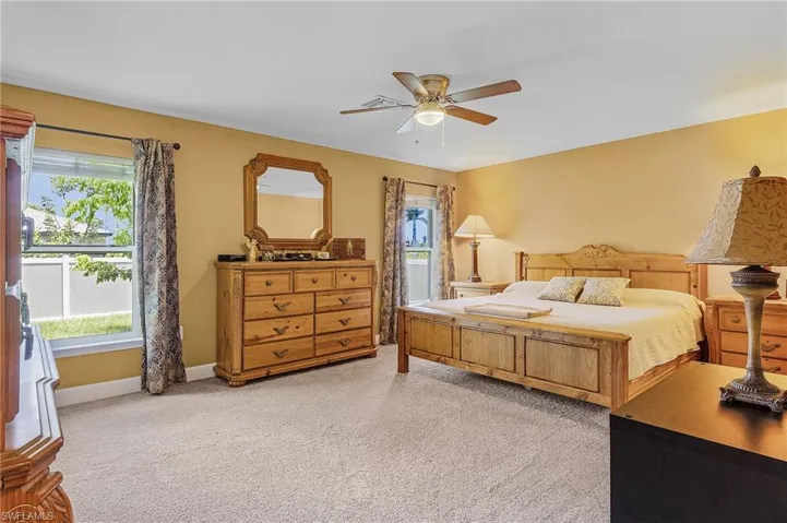 Bedroom with ceiling fan and light colored carpet