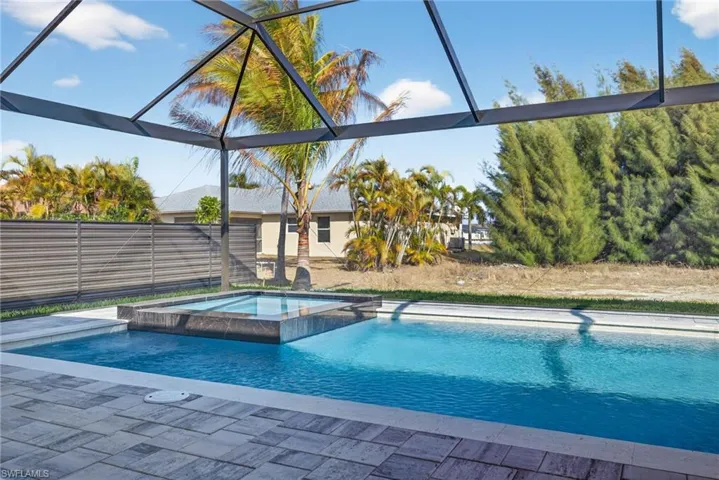 Combined pool / hot tub featuring glass enclosure and a sunroom