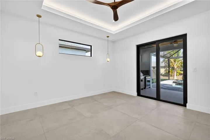 Spare room featuring a ceiling fan, a raised ceiling, and a sunroom