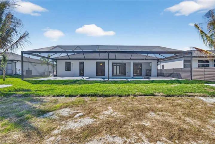 Back of property with a sunroom, glass enclosure, stucco siding, and a patio