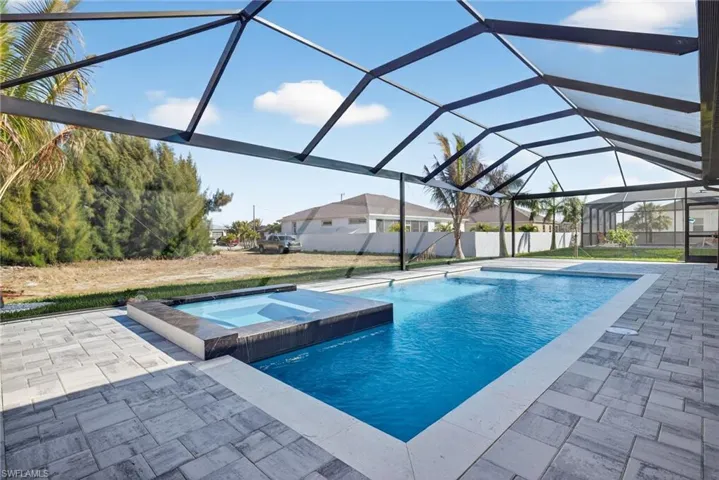 Combined pool / hot tub featuring a sunroom, a lanai, and a patio