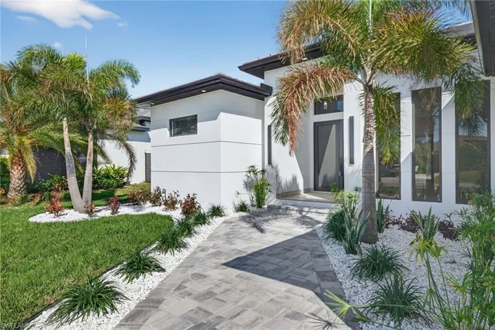 View of front of home with stucco siding and a front lawn
