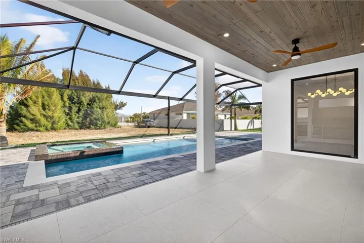Integrated pool / spa featuring a sunroom, a patio, and a lanai