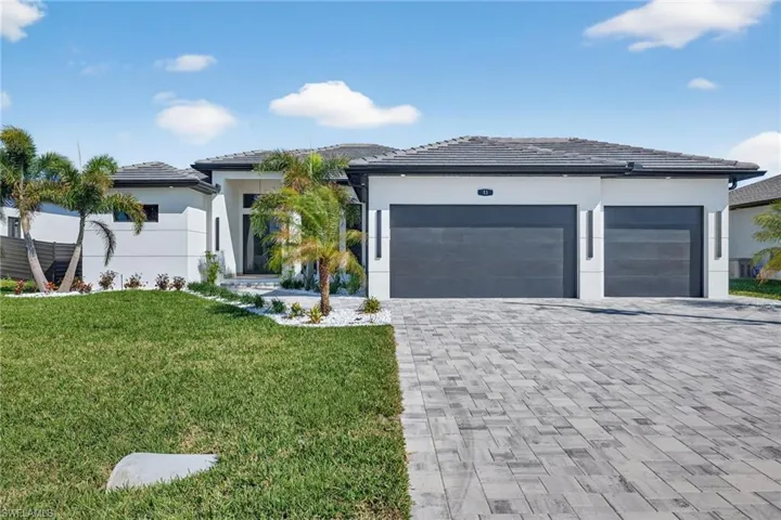 Prairie-style home with decorative driveway, a garage, stucco siding, and a front lawn