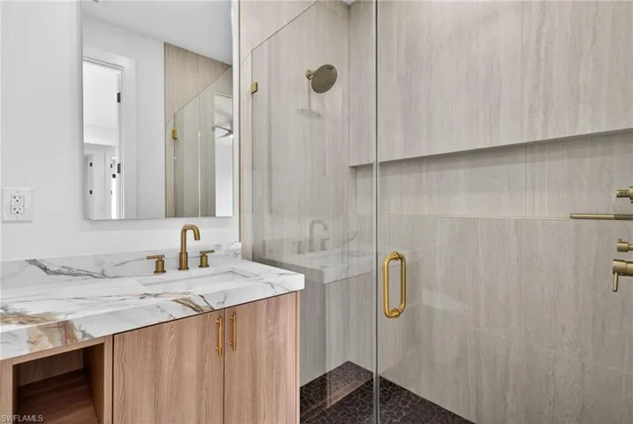 Bathroom featuring a shower stall and vanity