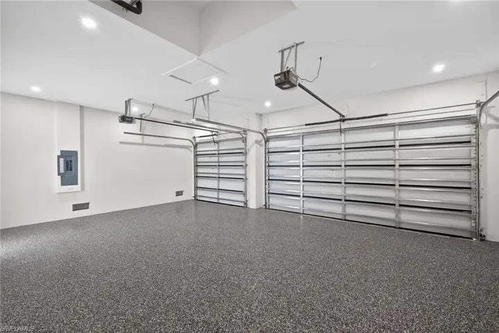 Garage featuring electric panel and a garage door opener