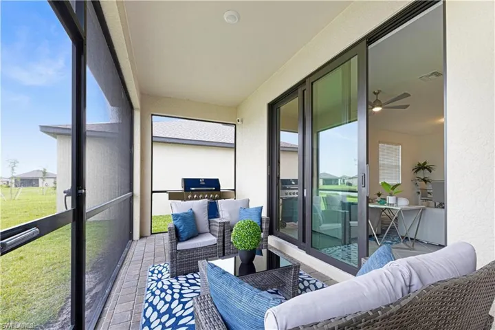 Screened-in patio featuring paver flooring, a built-in outdoor grill, and direct access to the interior via large sliding glass doors