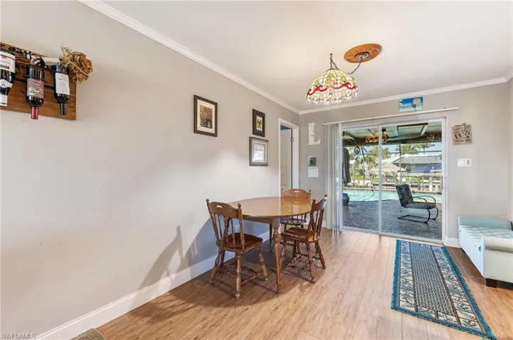 Dining area featuring wood finished floors and ornamental molding