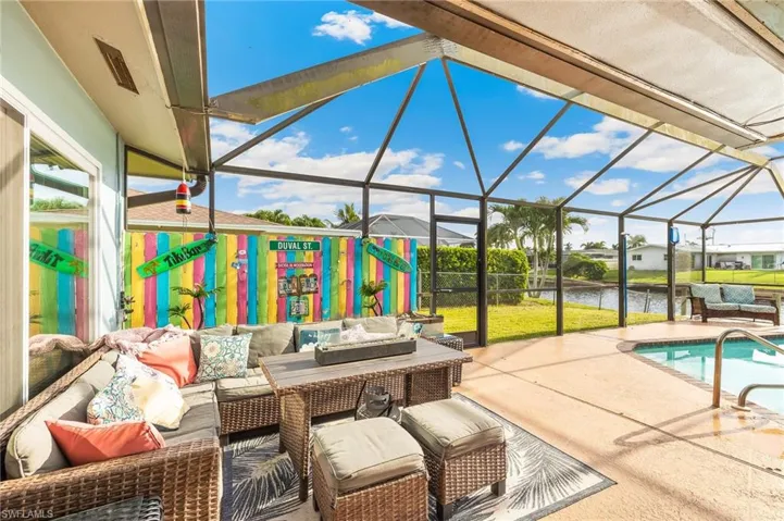 Swimming pool featuring an outdoor living space, a sunroom, a patio area, a lanai, and a water view