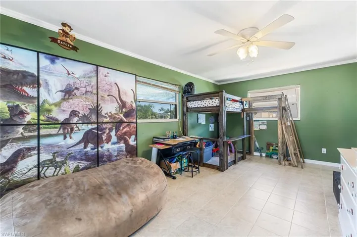 Bedroom featuring ornamental molding, a ceiling fan, and light tile patterned flooring