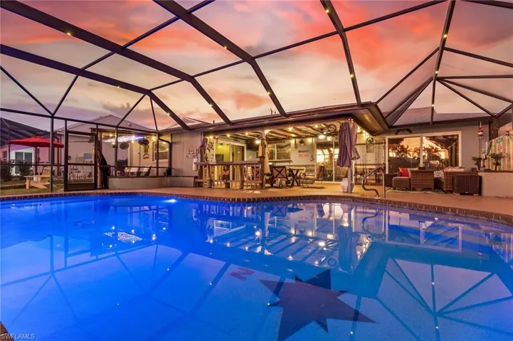 Pool at dusk featuring an outdoor pool and a sunroom