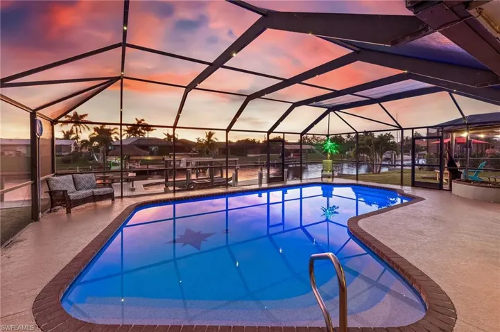 Swimming pool with a sunroom, a water view, a lanai, and a patio area