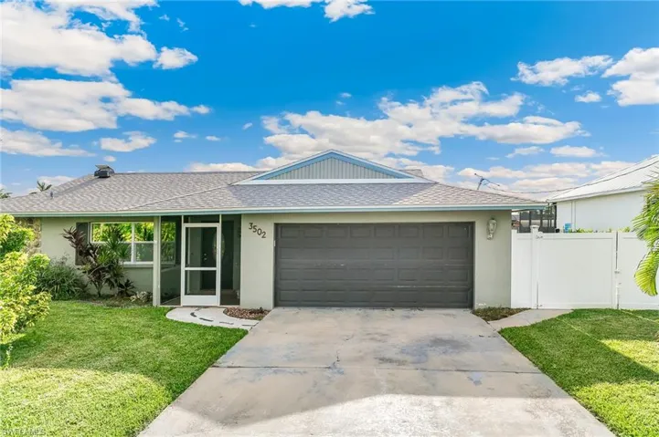 Ranch-style house featuring roof with shingles, stucco siding, a garage, and driveway