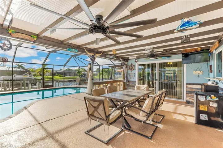 Sunroom featuring a patio area, outdoor dining space, beamed ceiling, and ceiling fan