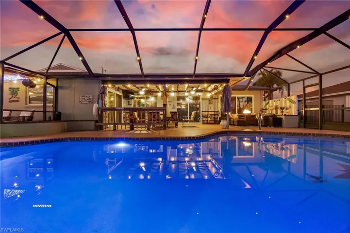 Swimming pool with a sunroom, a patio, and glass enclosure