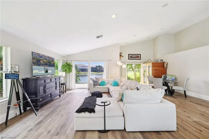 Living room with vaulted ceiling and light hardwood / wood-style floors