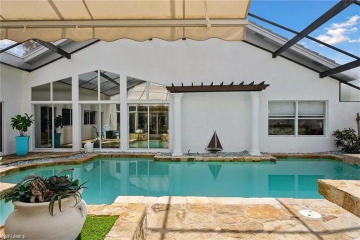 View of swimming pool featuring a lanai