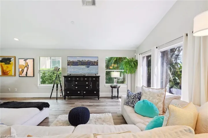 Living room with vaulted ceiling and vinyl prank flooring.
