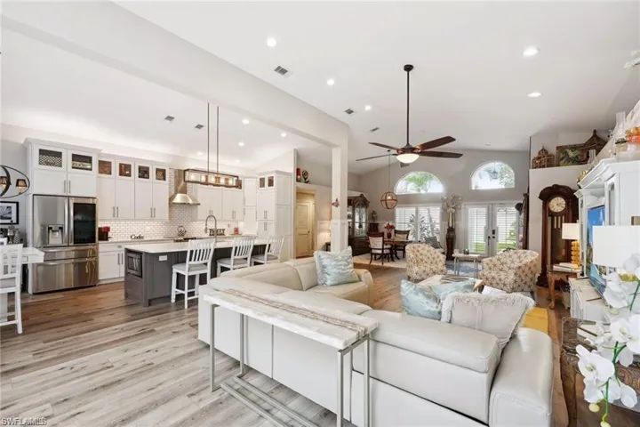 Living room featuring french doors, lofted ceiling, light hardwood / wood-style flooring, and ceiling fan