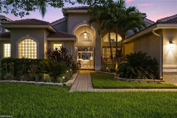 Exterior entry at dusk with a lawn