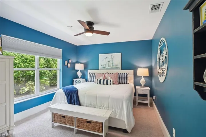 Carpeted bedroom featuring ceiling fan
