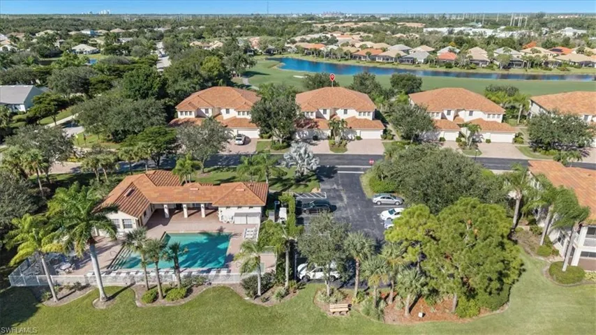 Aerial perspective of suburban area with a large body of water and a pool