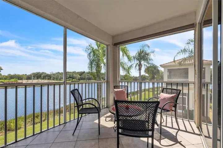 Sunroom / solarium with tile patterned floors and a water view