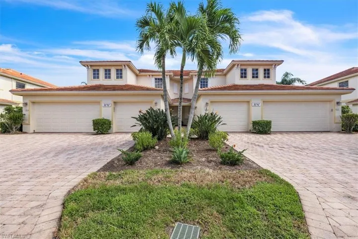 View of front of house with stucco siding, decorative driveway, and a tiled roof