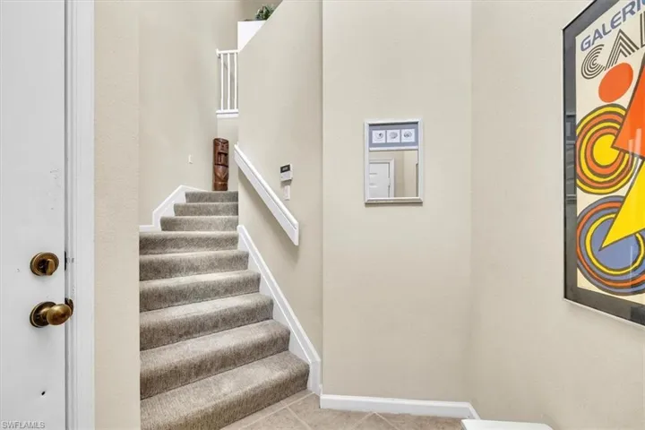 Stairs featuring baseboards and tile patterned flooring
