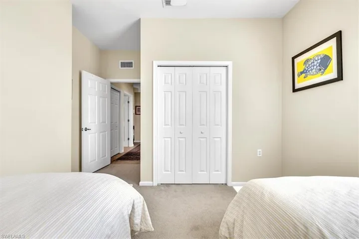 Carpeted bedroom featuring baseboards and a closet