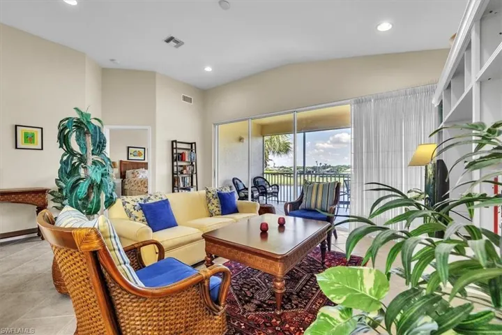 Tiled living area featuring lofted ceiling and recessed lighting