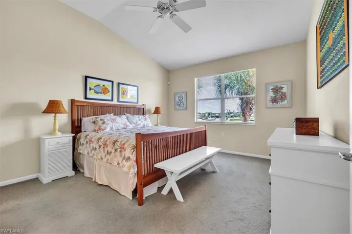Bedroom with light carpet, lofted ceiling, and a ceiling fan