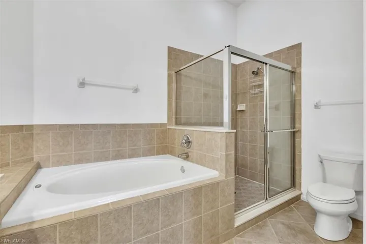 Full bathroom with a bath, tile patterned flooring, and a shower stall